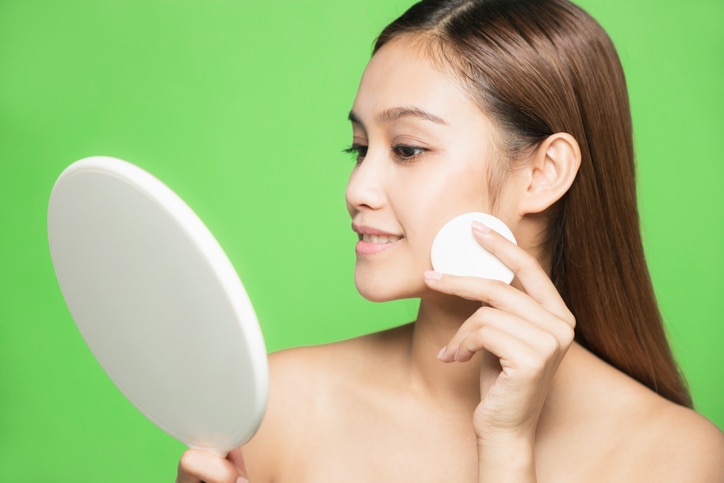 Young woman doing makeup. Skin care concept.