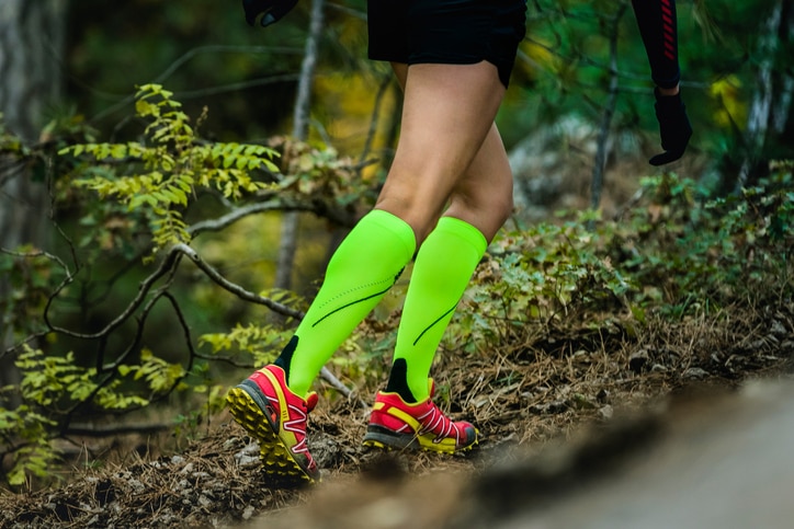 Yalta, Russia - November 2, 2015: closeup slender and beautiful legs of woman running  in compression socks. fitness and exercise in forest during Mountain marathon "Vertical kilometre AI-Petri"