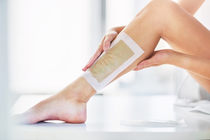 Closeup shot of an unrecognizable woman waxing her legs in the bathroom at home