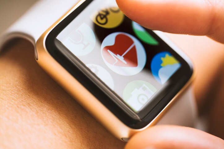 Close up shot of woman wrist wearing smart watch. Finger touching appwith heart beat icon on touchscreen.